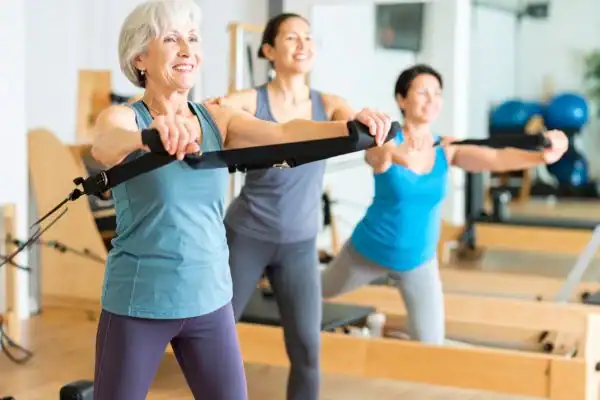 Toning Arms After 60: Empowering Womens Fitness Through Effective Weight Training 2 older woman doing weight training Redhill and resistance in the gym to tone upper arms