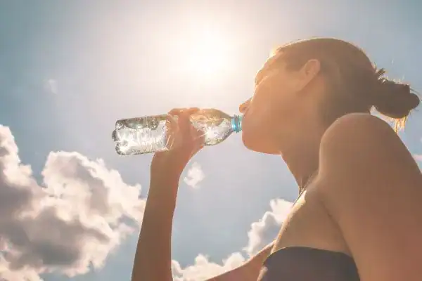 Hydration: The Secret Ingredient for a Toned Stomach and Enhanced Fitness 3 Image of woman drinking water to hydrate Redhill after run.