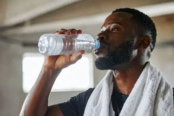 Hydration: The Secret Ingredient for a Toned Stomach and Enhanced Fitness 1 Image of man drinking water to improve hydration Redhill after work out.